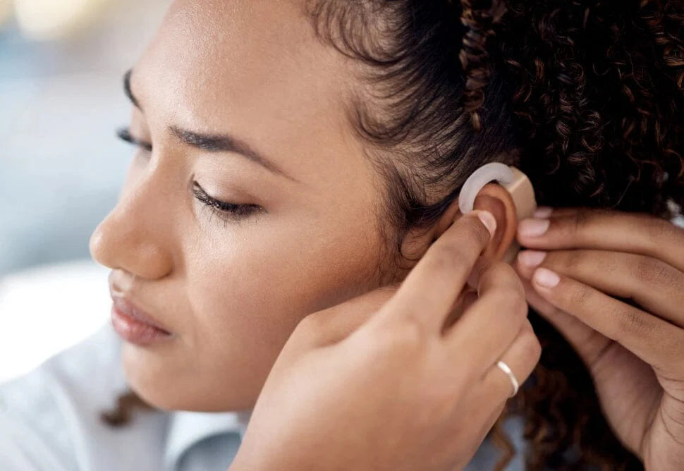 Woman putting on a hearing aid