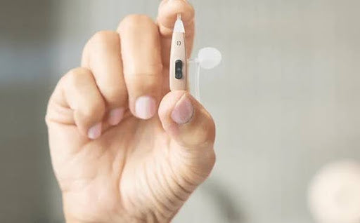 A person holding a Nano hearing aid.