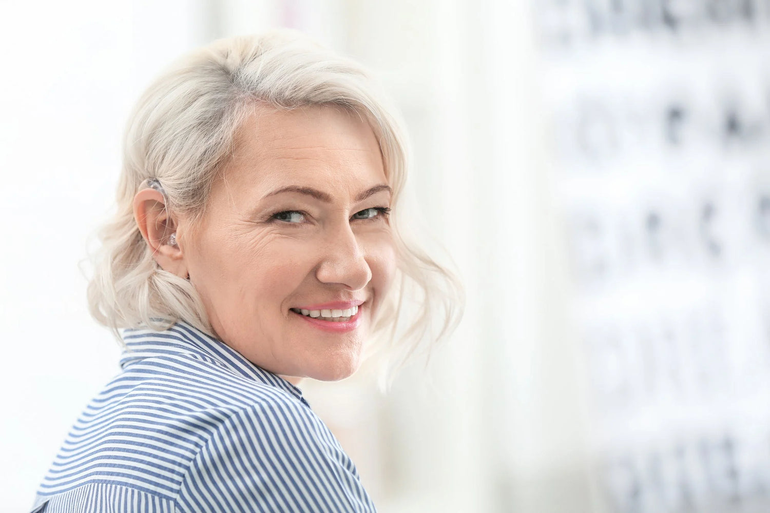 Smiling senior woman wearing hearing aids.